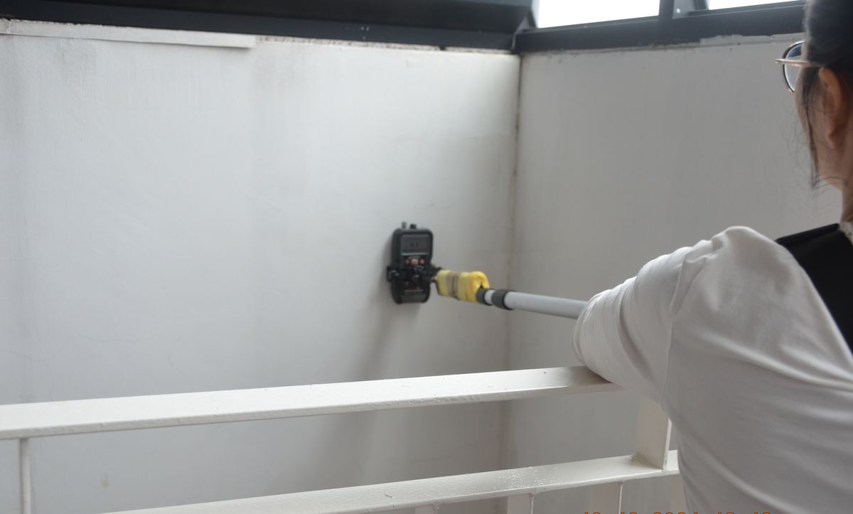 Surveyor testing balcony walls with a moisture probe